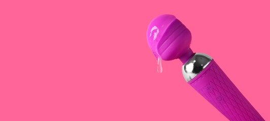 Vibrator with intimate lubricant on pink background with space for text