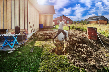 Digger jumps over an absorption trench during installation work on septic tank.