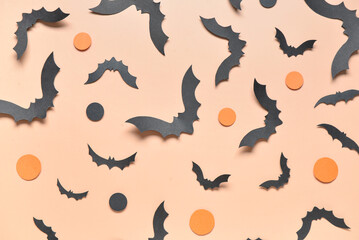 Paper bats for Halloween party on orange background