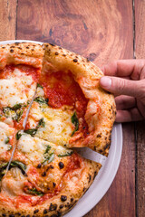 Gourmet Margherita Pizza Being Served on Rustic Wooden Table