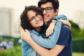 Obraz premium Couple, hug and outdoor with love for portrait, support or commitment in loyal relationship. Man, woman or embrace in park with glasses, milestone celebration or excited for holiday travel or journey