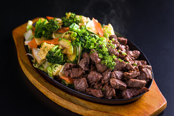 Sizzling Beef Teppanyaki with Fresh Vegetables on Heated Cast Iron Plate