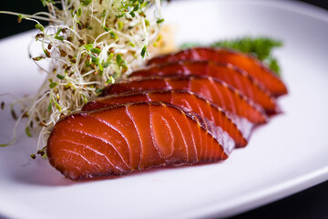 Delicious Sliced Smoked Salmon With Fresh Sprouts on White Plate