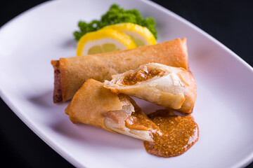 Delicious Crispy Spring Rolls with Savory Dipping Sauce on Plate