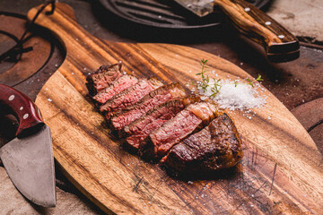Juicy Grilled Steak Slices with Seasoning on Wooden Board