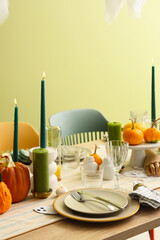 Festive table setting with burning candles and pumpkins for Halloween party