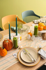 Festive table setting with burning candles and pumpkins for Halloween party