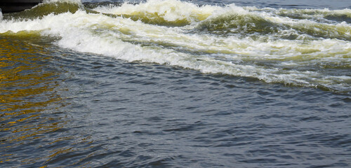 Rippling water surface with dynamic waves reflecting sunlight, creating a mesmerizing pattern