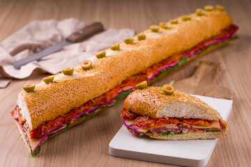 Delicious Gourmet Baguette Sandwich with Fresh Vegetables and Green Olives Garnish