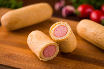 Delicious Sausage Roll on Wooden Cutting Board with Fresh Ingredients