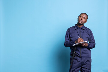 African american security agent writing details on his notebook files, keeps track of information...