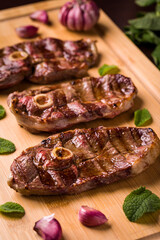 Grilled Lamb Chops With Garlic And Mint On Wooden Board