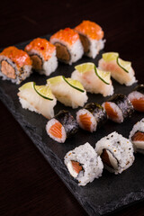 Assorted Sushi Rolls on Slate Plate with Lime Garnishes