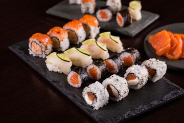 Variety of Sushi Rolls and Sashimi on Slate Serving Boards