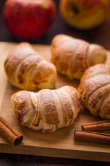 Delicious Apple Pastries with Cinnamon Sticks on Wooden Board