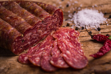 Delicious Sliced Salami with Spices on Rustic Wooden Table