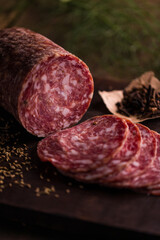 Delicious Sliced Salami with Herbs on Rustic Wooden Board
