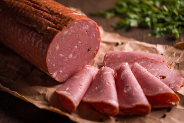 Freshly Sliced Mortadela on Rustic Paper with Herbs Nearby