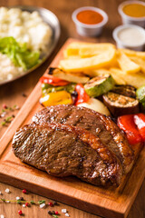Delicious Grilled Picanha Steak and Vegetables on Wooden Platter with Sauce