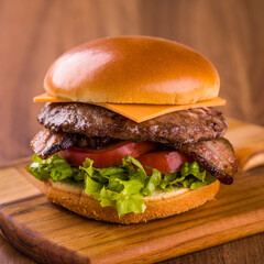 Juicy Cheeseburger with Bacon on a Wooden Cutting Board