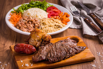 Delicious Brazilian Barbecue with Traditional Sides on Wooden Table