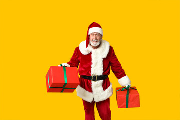 Shocked Santa Claus with gift boxes on yellow background