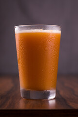 Refreshing Glass of Orange Juice on Wooden Tabletop