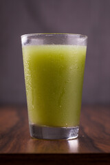 Refreshing Green Juice in a Clear Glass on Wooden Table