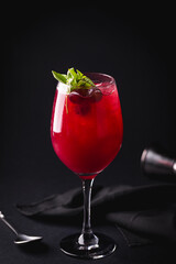 Refreshing Red Cocktail With Basil Garnish on Dark Background