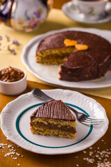 Delicious Chocolate Cake Slice with Orange Garnish and Ceramic Dishes
