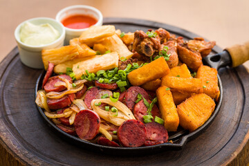 Delicious Skillet With Sausages, Fried Yucca, and Crispy Chicken Bites