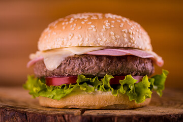 Juicy Burger with Fresh Lettuce and Tomato on Wooden Surface