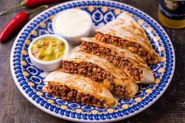Delicious Beef Quesadilla with Guacamole and Sour Cream on Plate