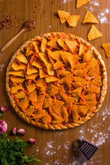 Delicious Nacho-Topped Pizza with Cheese and Ingredients Around