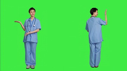 Healthcare specialist presenting a thing for promotional ad in studio, pointing at something against greenscreen backdrop. Medical assistant creating a web commercial, health expertise. Camera A.