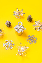 Composition with Christmas decorations and tinsel on yellow background