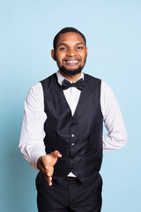 Bellhop hotel concierge greeting guests at the five star lodging resort, smiling and welcoming people against blue background. Personnel wearing a suit and tie, hospitality industry.
