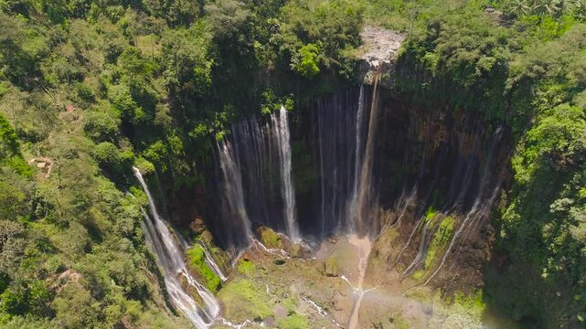 beautiful waterfall Coban Sewu in tropical forest, Java Indonesia. aerial view tumpak sewu waterfall in rainforest aerial footage
