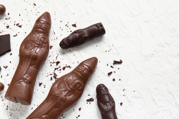 Composition with chocolate Santa Clauses and candies on light background