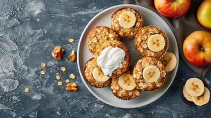 Bird's-Eye View of Oat Muffins, Apple and Banana Cakes with Sour Cream on White Plate: Healthy Dessert Assortment on Blue Stone Background