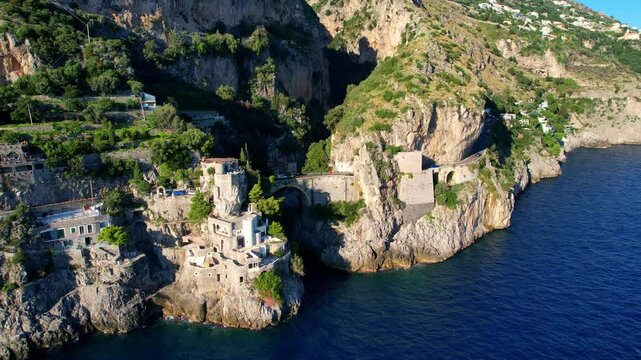 4K Aerial view of very unique bridge over a beach in narrow cliffs on a beautiful sunny day. Famous tourist attraction Fiordo di Furore on the picturesque Amalfi coast in Italy