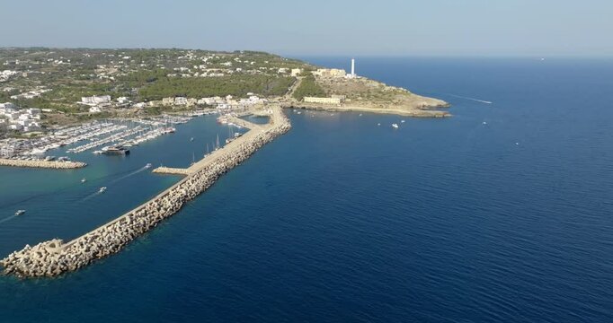 Aerial view of the Leuca lighthouse on the top of Punta Meliso. This is located in Santa Maria di Leuca in Salento, Puglia, Italy. In foreground is the touristic port of the city.