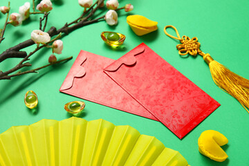 Envelopes with flower branch, fortune cookies and Chinese symbols on green background. New Year...