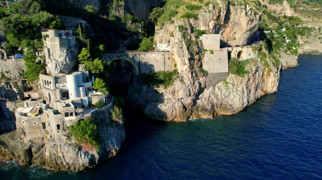 4K Aerial view of very unique bridge over a beach in narrow cliffs on a beautiful sunny day. Famous tourist attraction Fiordo di Furore on the picturesque Amalfi coast in Italy