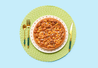 Plate of sweet tart with different nuts and caramel on blue background