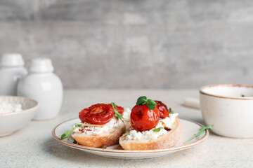 Plate of tasty tomato bruschetta with ricotta on white table