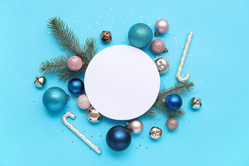 Blank card, Christmas balls, confetti, candy canes and fir branches on blue background