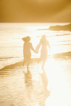 Two lesbian women enjoying a sunset walk on Playa de Nerga