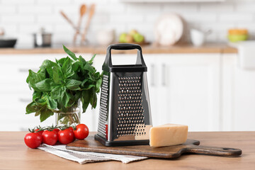 Cutting board, napkin, cheese, tomatoes and grater on table in kitchen
