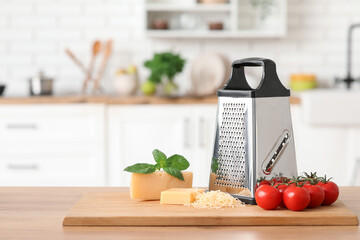 Grater, ingredients and cutting board on table in kitchen